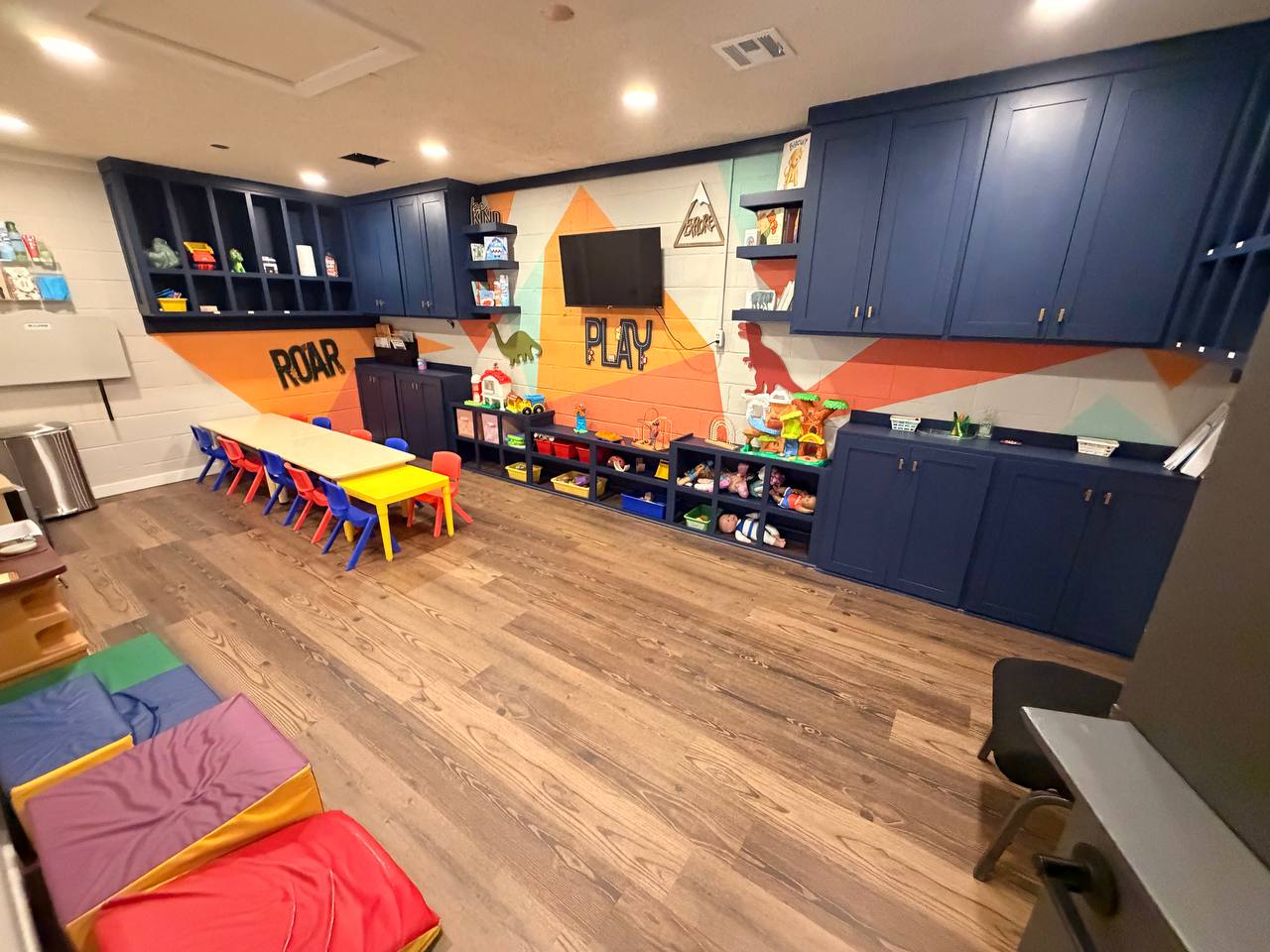 Toddler room — navy cabinetry and painted play mural