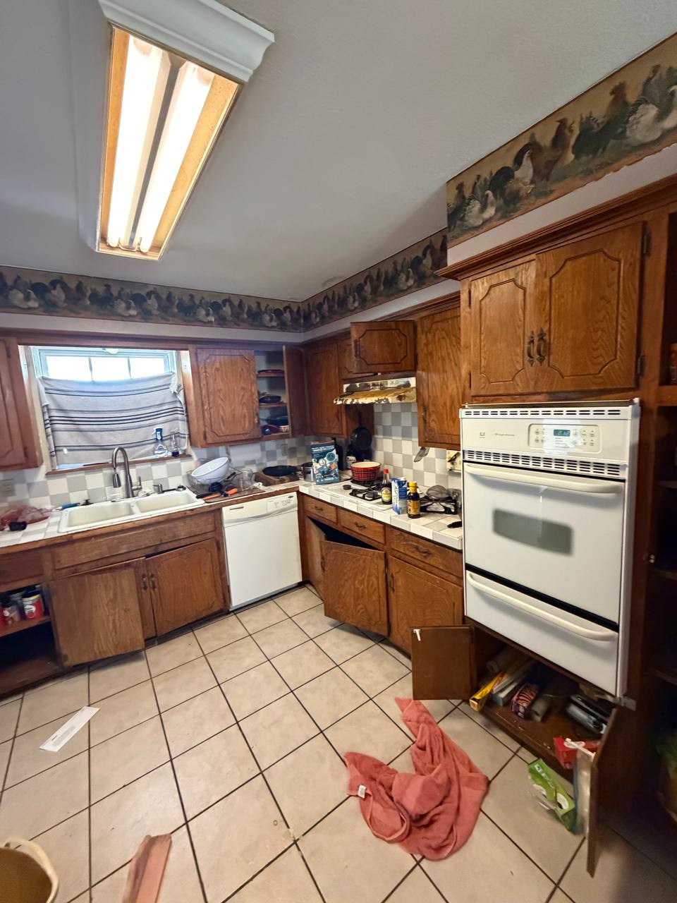 Before — oak cabinets, tile counters, and a fluorescent light box
