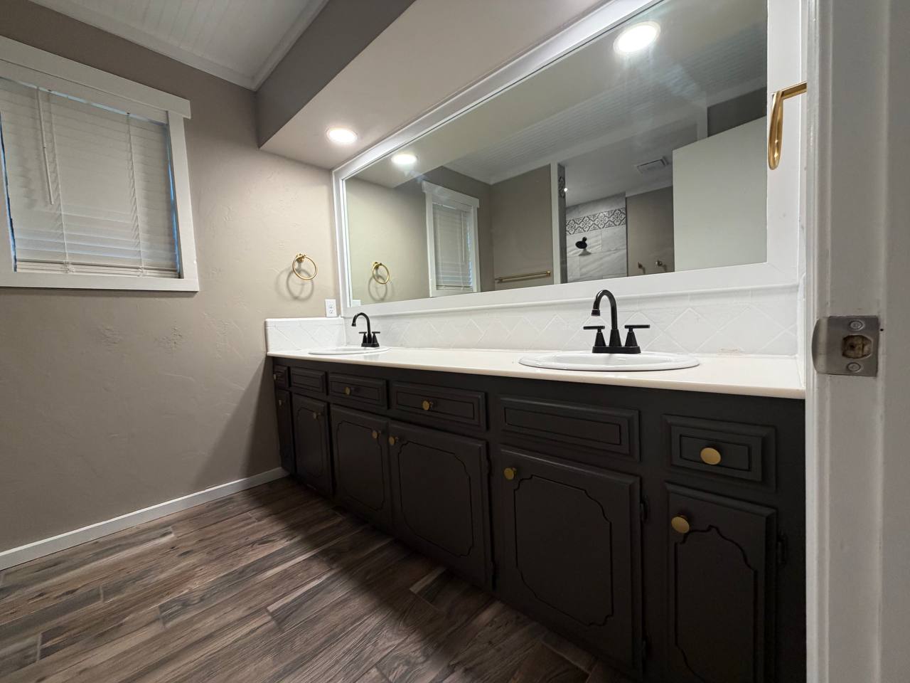 Painted double vanity with black faucets and brass hardware
