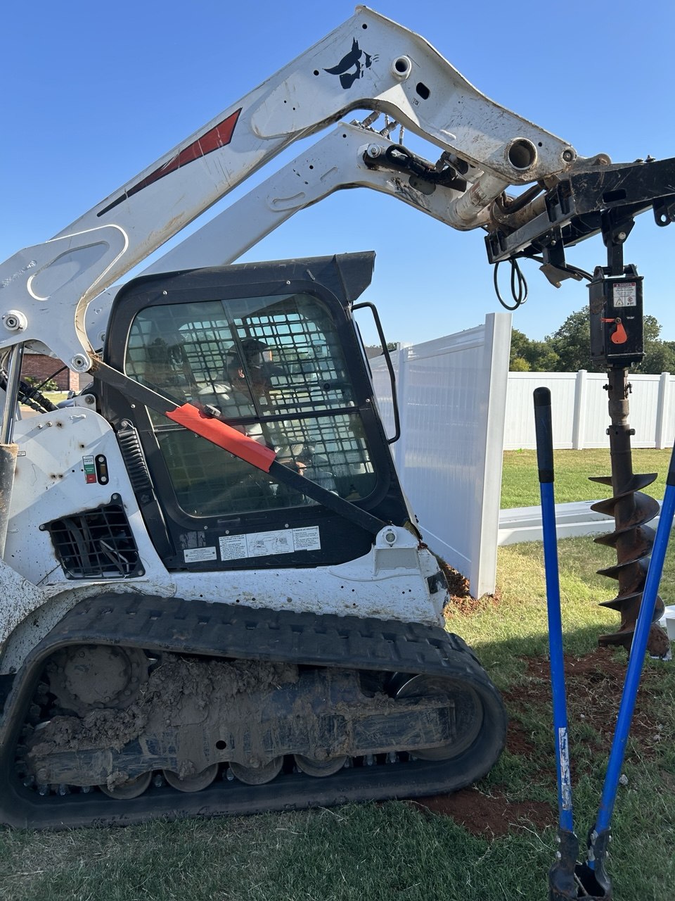 Skid steer and auger staged before the first hole
