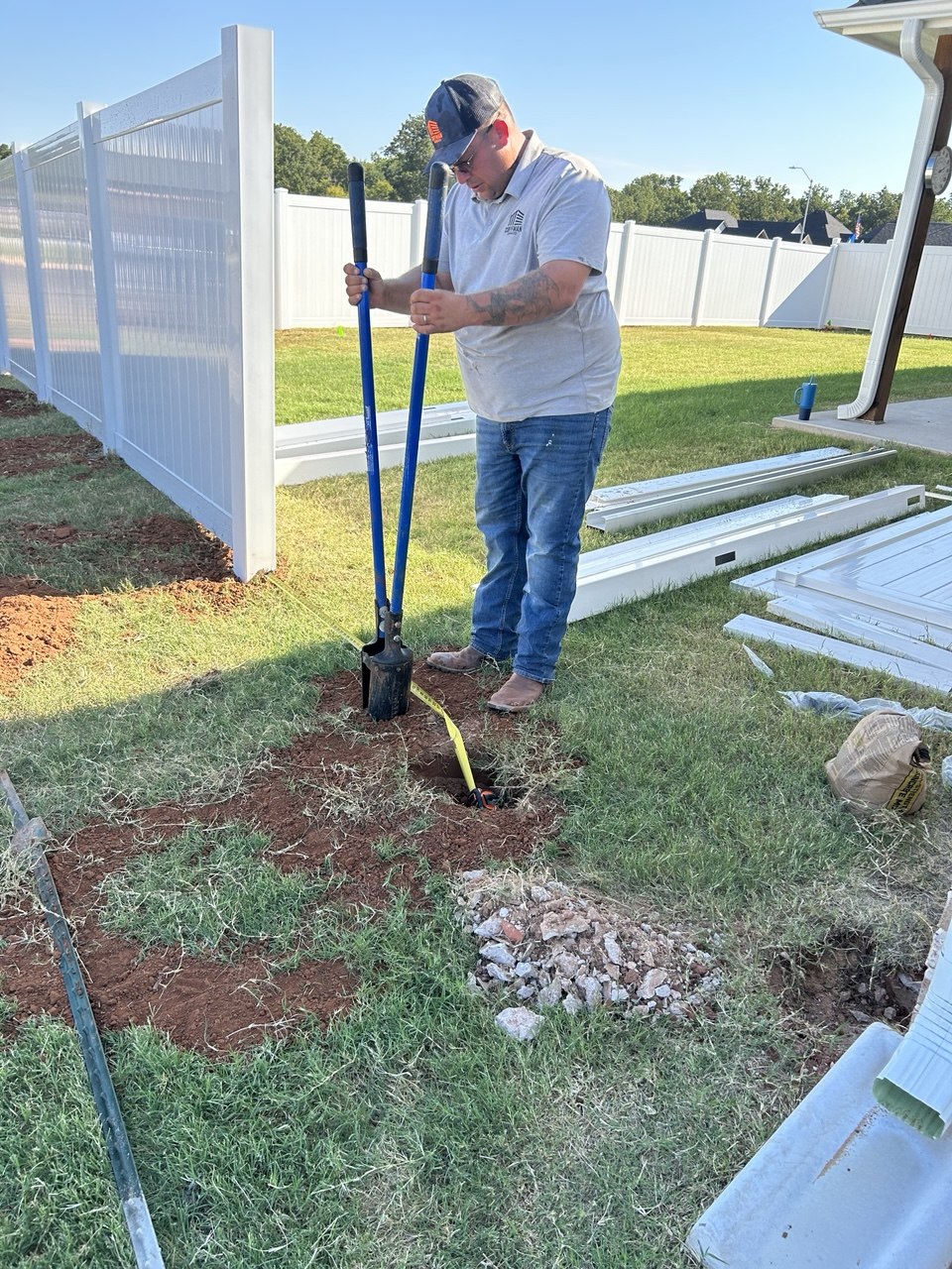 Cleaning out a post hole by hand around utilities